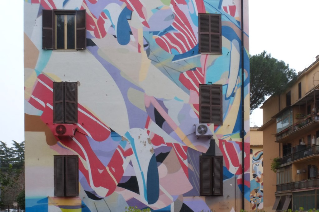 large mural on the side of a four storey apartment building in Tor Marancia, Rome, abstract design by Rafael Gerlach