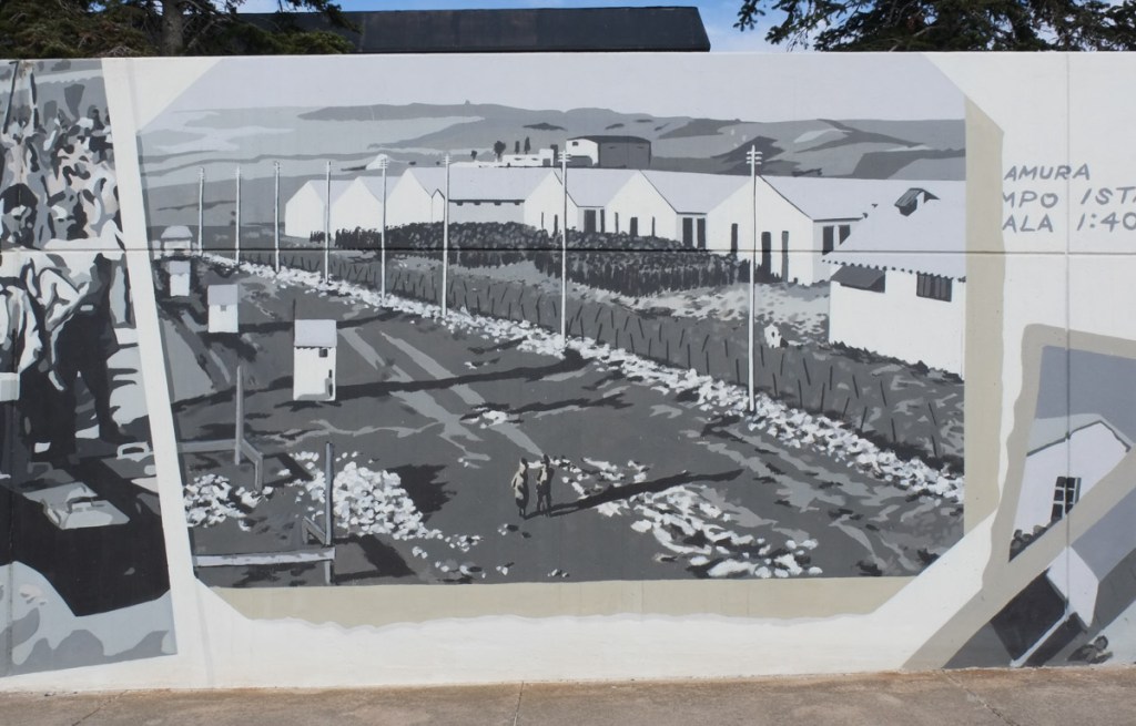 mural in shades of grey using images of old photographs from Camp 65 from WW2, row of white buildings, barracks