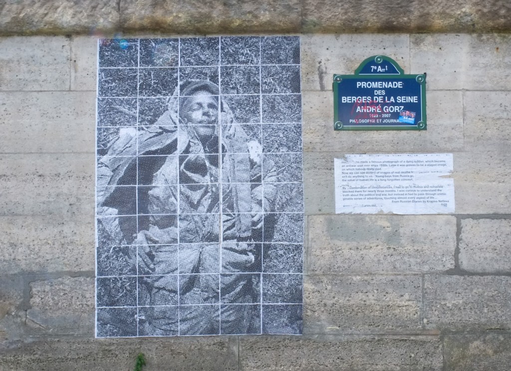 faded large black and white photo mounted on an outside wall