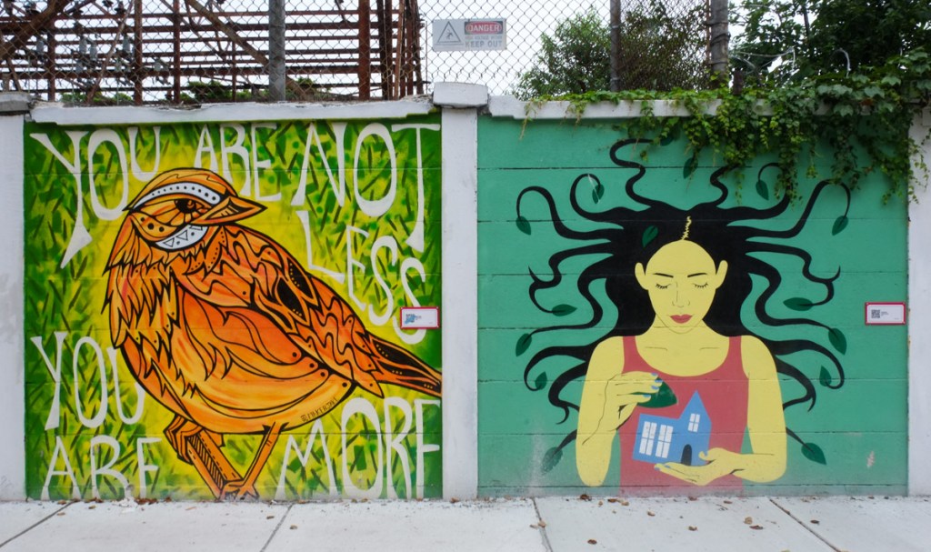 two murals on a fence in salem, on left, a gold and orange bird