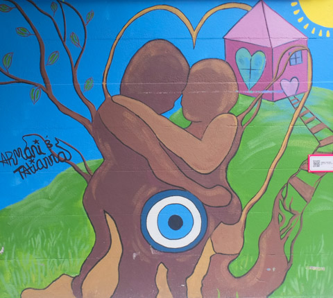 mural on a fence, a couple hugging