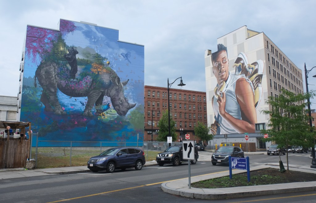 2 very large murals in Lynn Massachusetts, one by Ernesto Maranje with a rhino and the other by smug of a young man with his shoes