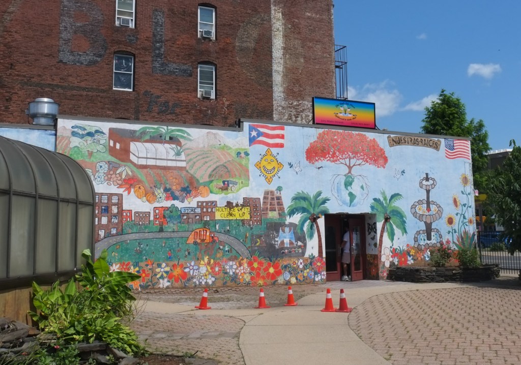 mural on the side of a bakery, with garden in front