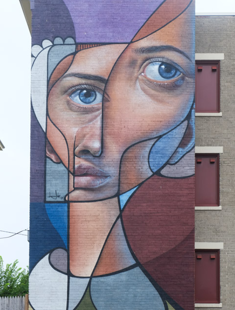 large vertical mural by Belin, of a person, split face, post neo cubism, 