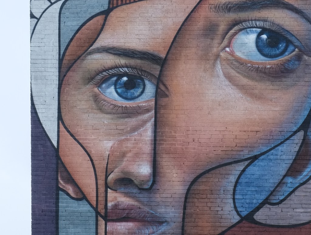 close up of the face of the person in large vertical mural by Belin,  split face, post neo cubism,