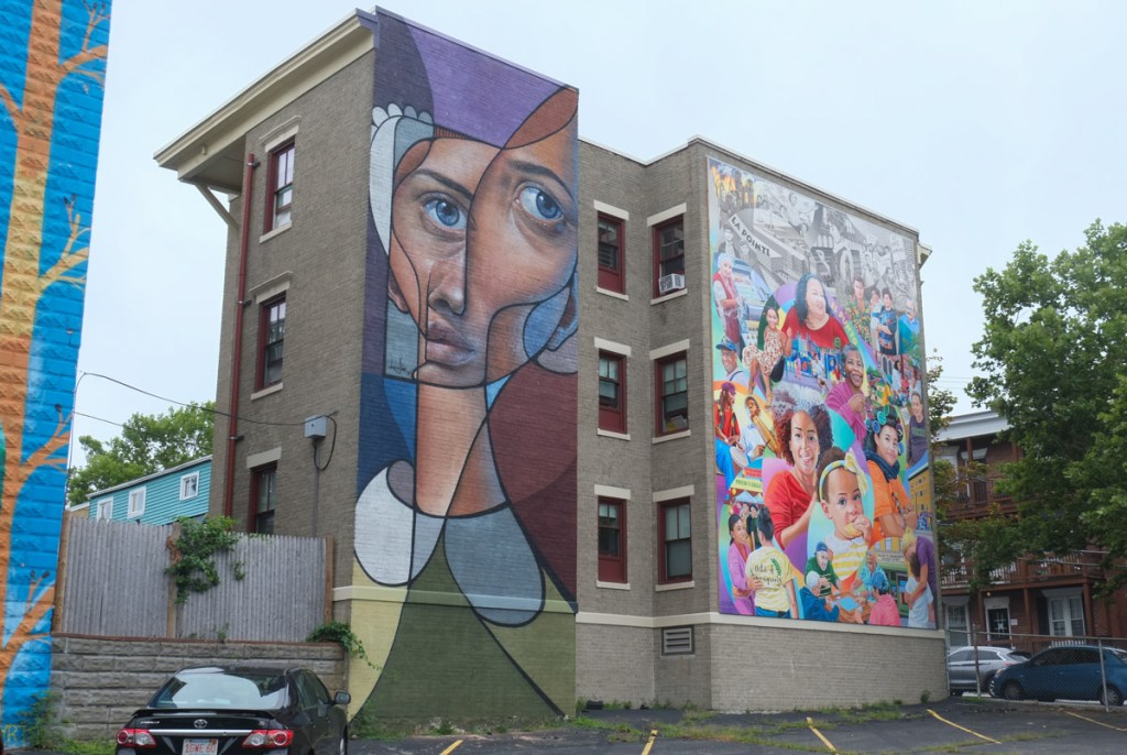 two murals on adjacent apartment buildings on congress street in salem massachusetts, one by belin and one designed by david fichter