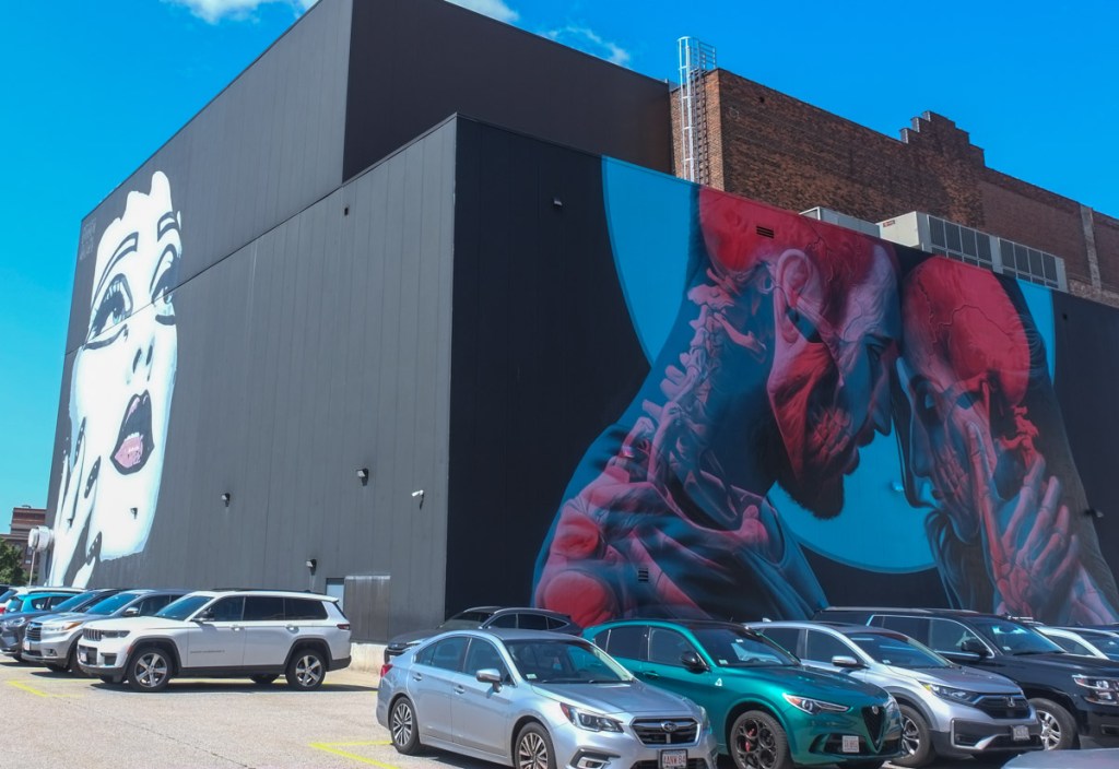 2 murals on the Hanover theatre in Worcester, both very large, a white woman's portrait by Damien Mitchell, blue eyes and reddish purple lips on one side, and a blue and red mural by insane 51 on another side 