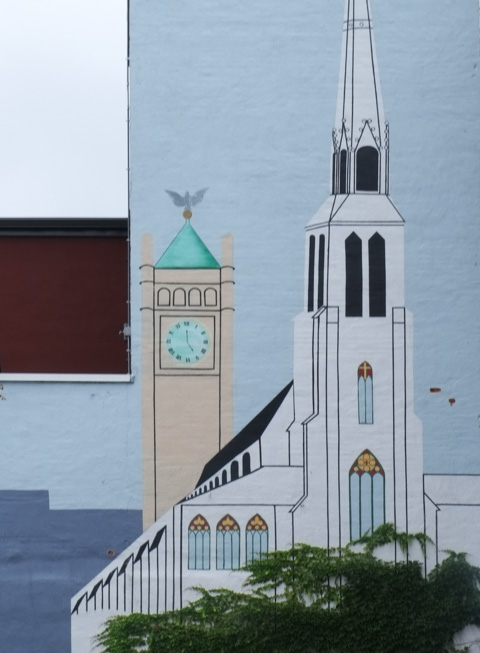 part of a larger mural showing scenes from around lowell massachusetts, two church steeples