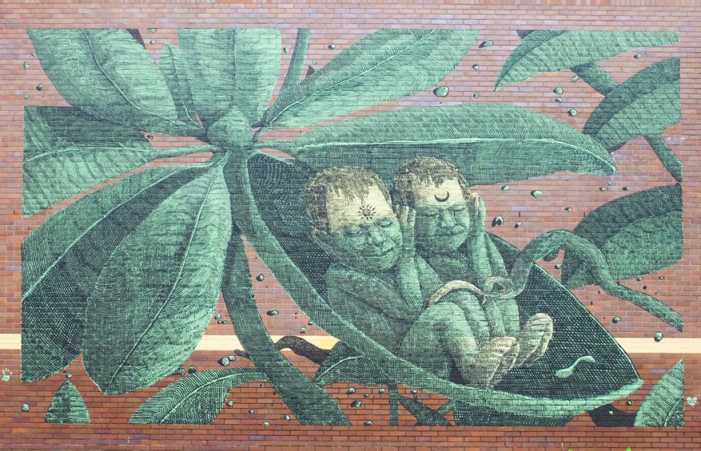 mural in green tones, on a red brick wall, lots of detail, two little people with eyes closed together in a pea pod, pea plant, painted by hanimal
