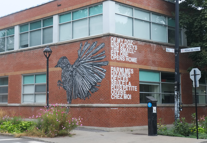 black and white mural on side of brick building, a bird with large wings