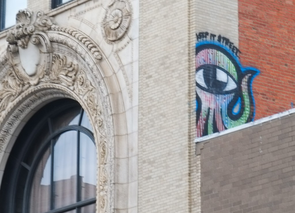 small street art piece high up on a building, keep it street