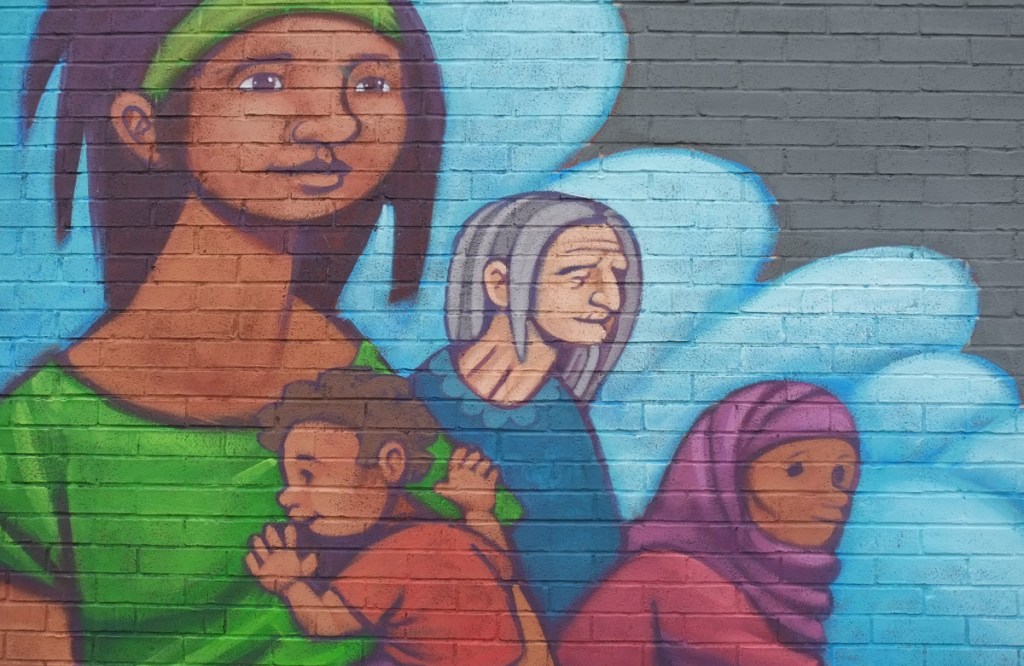 woman, grandmother, and children in a mural 
