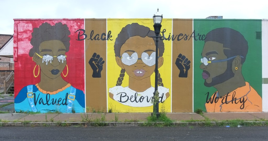 black lives matter mural, portrait of three people with a word associated with each, valued, beloved, worthy, 