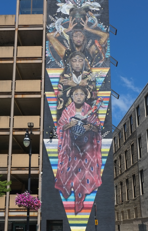 marka27, or Victor Quinonez, mural of 3 women forming a tower, younger girl on bottom, older woman on top