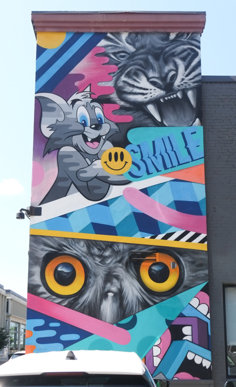 mural with cartoon like characters, mouse from Tom and Jerry, the word smile, a tiger with long front teeth, an owl with big eyes