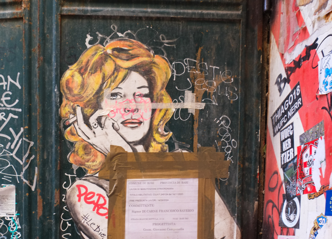 graffiti by LeDieSis, blond woman, other graffiti around her