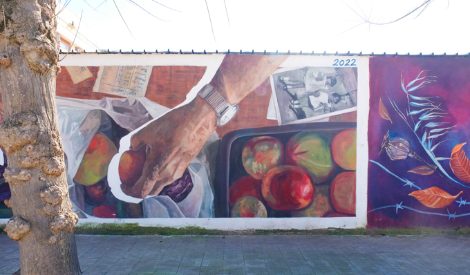 street art mural on a wall in Stornara Italy, sorting apples and putting some in a bag