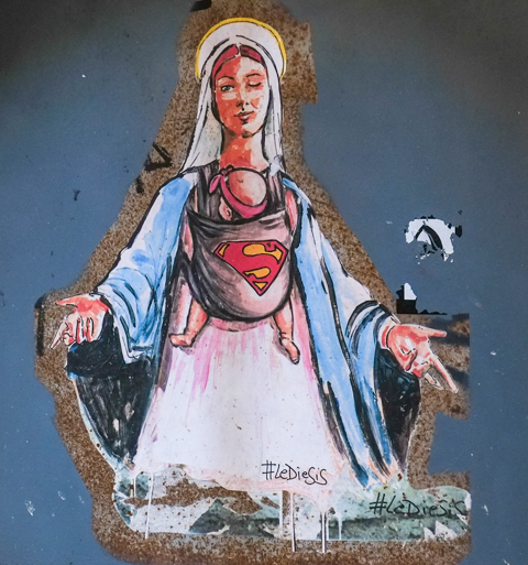 street art by LeDieSis, Virgin Mary in white robes with blue scarf or coat over shoulders, wearing baby carrier on her front, with baby, superman symbol on baby's back