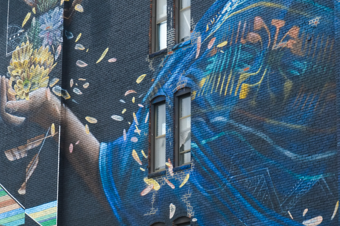 close up of a part of a mural by marka27, hand out with yellow flowers