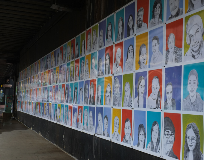 raw art works portrait project in lynn massachusetts, many portraits hanging under an overpass