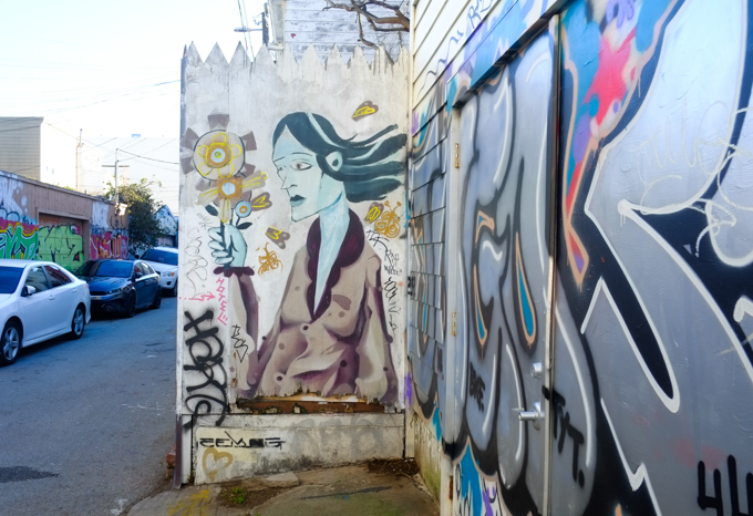 mural of a woman with long hair, holding a bouquet of flowers