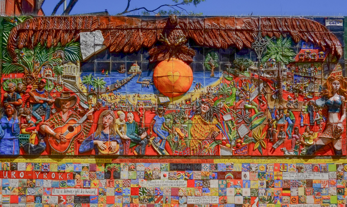 central image in a street art mural made of ceramis. the central image has many elements, in general it is a seaside view of St. Kilda with Luna Park, and the St. Kilda marina.