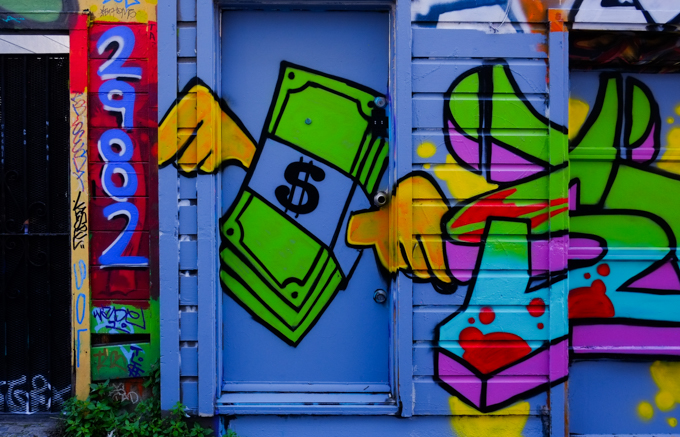 street art painting on a blue door, bundle of dollar bills with yellow wings flying away, number beside door is 2982