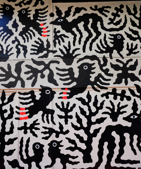 part of a mural by minna leunig, black stylized kangaroos and birds on a white background