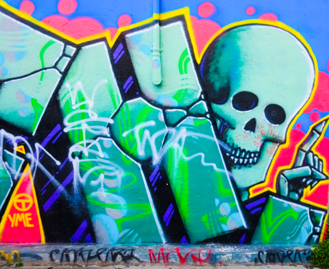 street art, throw up looks like rock or cracking concrete, with a skull