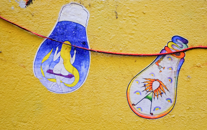 paper pasteup on yellow wall, shape of a light bulb,