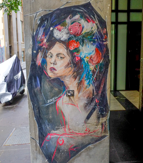 street art image of a young woman with a bouquet of flowers where her hair should be