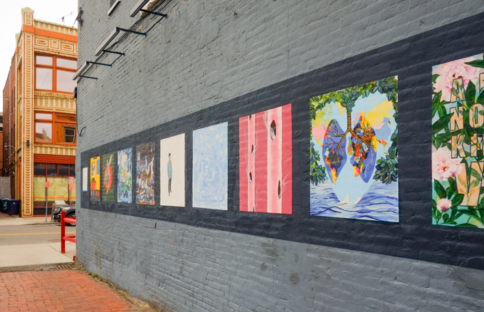 a row of paintings, part of a series called Works from Home, Covid themed images by local artists, presented by Albright Knox gallery