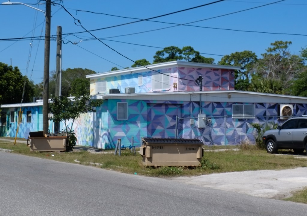 two storey house painted in design of blue, pink, and purple triangle patterns