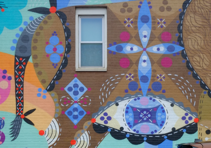 part of a mural, large mural on the side of Joe's deli, a brown buffalo decorated with lots of stylized flowers and floral motifs, painted by Bunnie Reiss