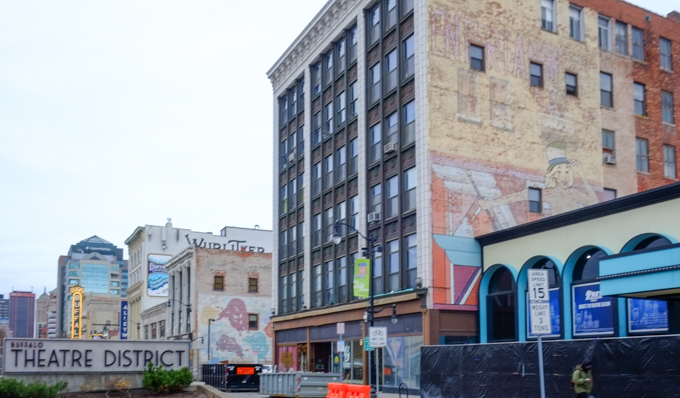 Main Street in Buffalo in Theatre District, two older brick buildings with faded murals on them