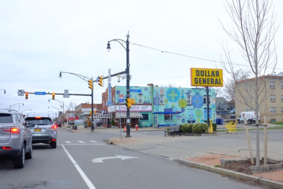 intersection of Hertel and Colvin, in Buffalo New York, Joe's deli is on the corner, covered with a mural by Bunnie Reiss. A Dollar General store is on the other corner and it has a large sign