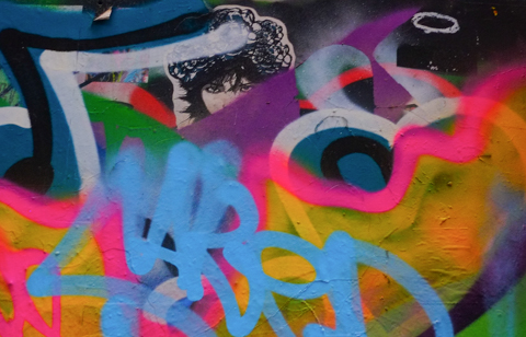 spray paint covers most of a black and white sticker of a face so only the eyes show