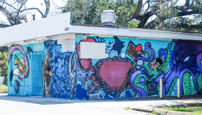 mural with flamingo head and neck, a big purple crab, and an octopus