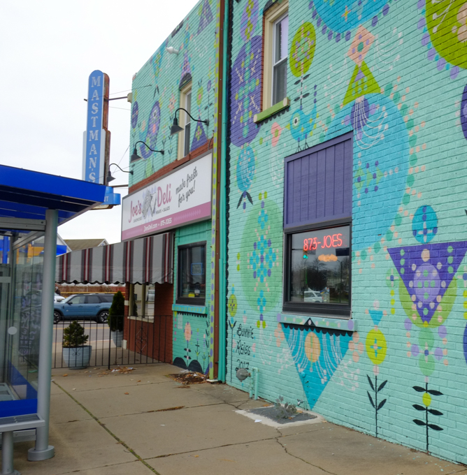 mural by Bonnie Reiss, stylized floral motifs in blues and purples on a bright turquoise background