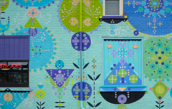part of mural by Bonnie Reiss, stylized floral motifs in blues and purples on a bright turquoise background