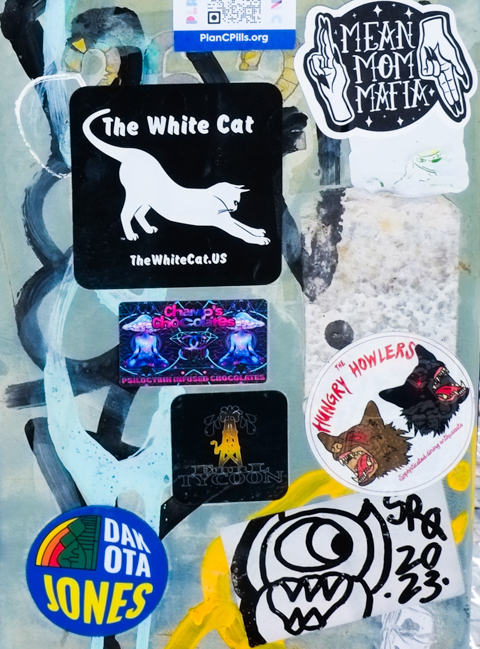 graffiti stickers including mean mom mafia, and the white cat, and the hungry howlers