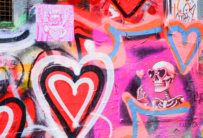 spray painted street art hearts in Hosier Lane, along with an image of a skeleton wearing heart shaped sunglasses