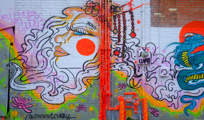 part of a mural by coconut curry, a woman's face in profile with large red circle on her cheek