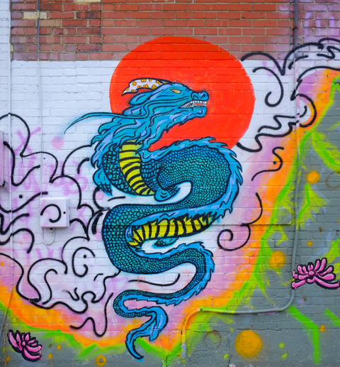 part of a mural by coconut curry, a blue Chinese style gragon with open mouth and teeth, on clouds, 