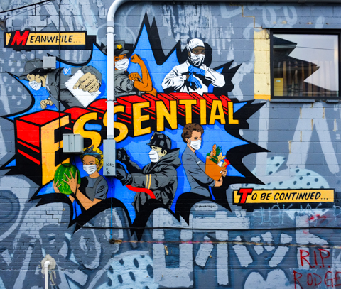 mural in an alley, covid theme, text says essential, images of medical people and others in covid masks