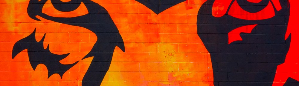 just the eyes from a large black and orange mural of a lion's face