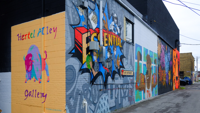 building in an alley with street art murals on it, with sign that says Hertel Alley Gallery