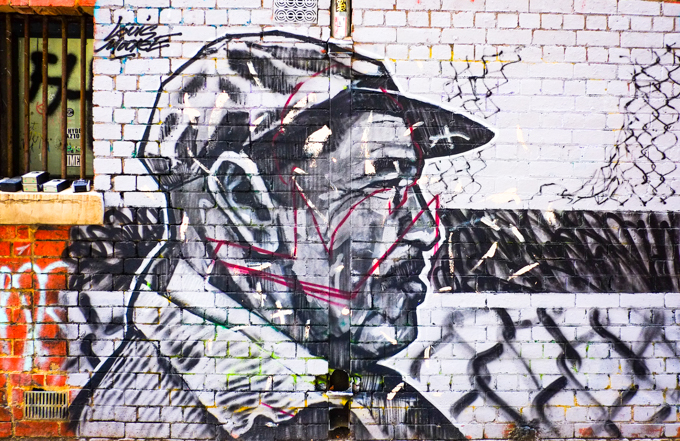 mural of a man in a cap, in profile, in black and grey on a white background, 