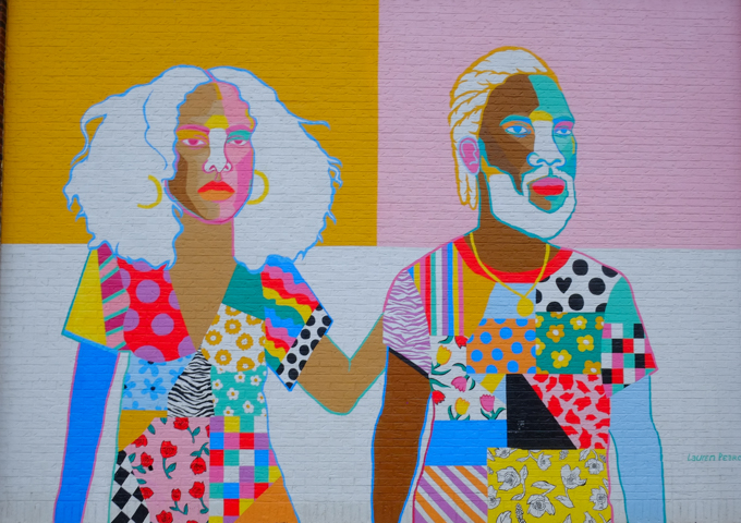 a coupe with white hair, dressed in patchwork clothes, white woman, black man, man has a beard and mustache. 