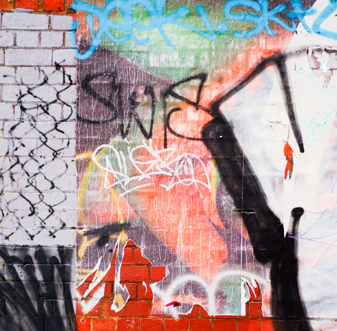 bits of paper, remnants of a photograph on disply in an alley, outdoors, weathered and old